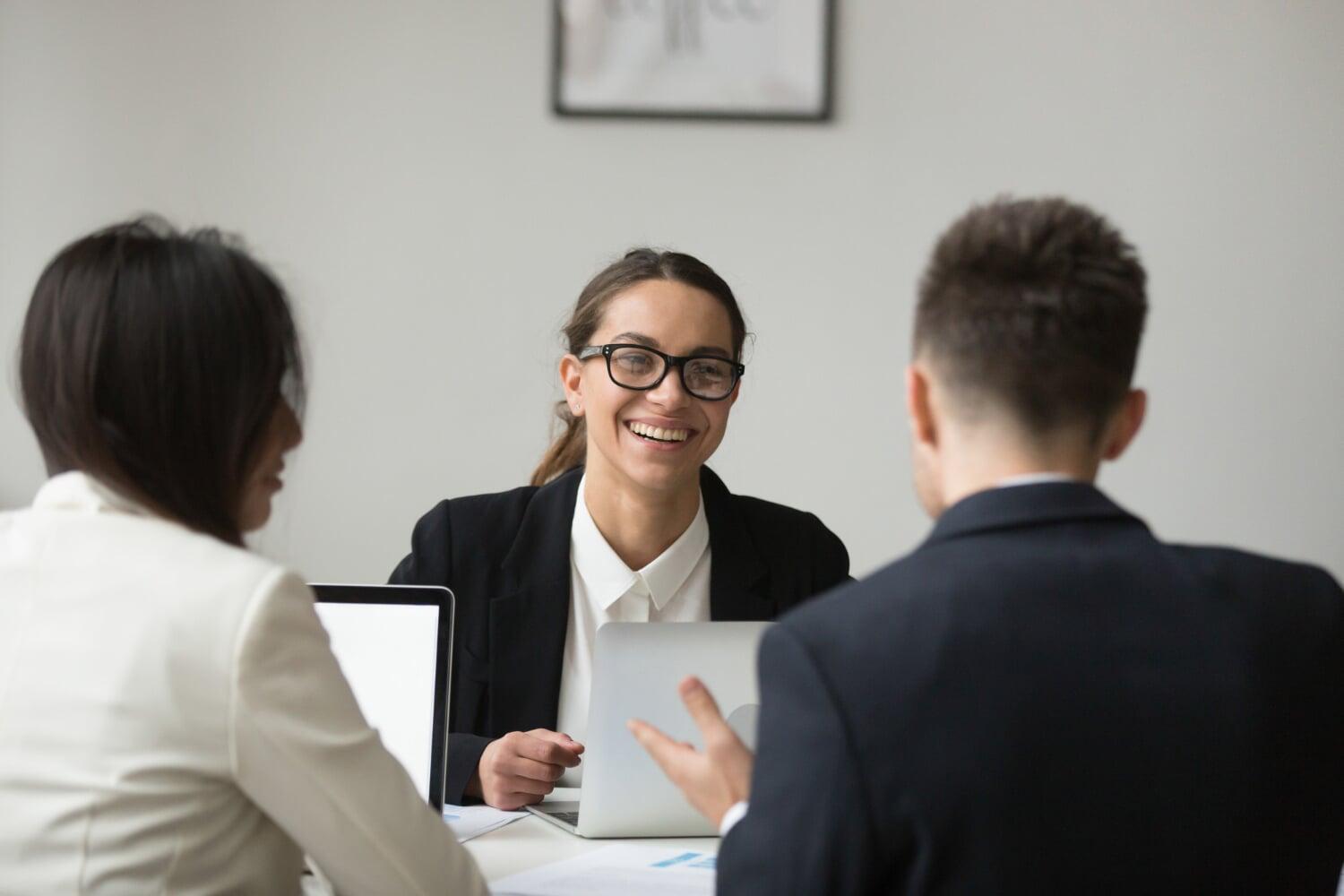 Profissionais reunidos em ambiente corporativo discutindo estratégias com expressão positiva