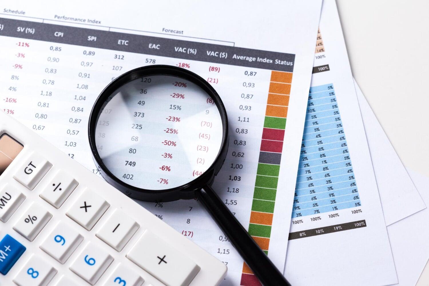 Lupa ampliando números negativos em planilha financeira com dados e gráficos